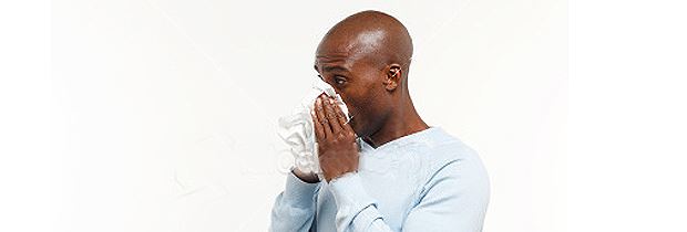Man Blowing Nose in Tissue